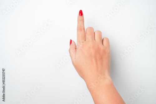 Flat lay photo of A woman's hand with bright red nail polish is making a pointing or touching gesture with the tip of her index finger. Isolated on white background - Cut Out