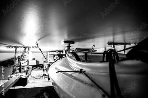 Selective focus on the side of a kayak that has used a Hoist and pulley system to store on the ceiling of a garage. photo