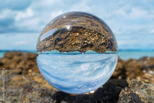 Glass Ball on the Rock, at the background is Panoramic View of Maraetai Beach Auckland, New Zealand photo