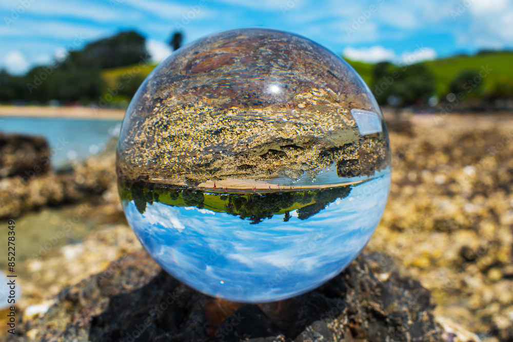 Glass Ball on the Rock, at the background is Panoramic View of Maraetai Beach Auckland, New Zealand