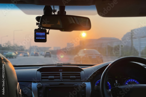 Bright and clear image interior of the car show steering wheel, dashboard, car stereo, car camera and air conditioning ventilation with traffic outside on summer morning background.