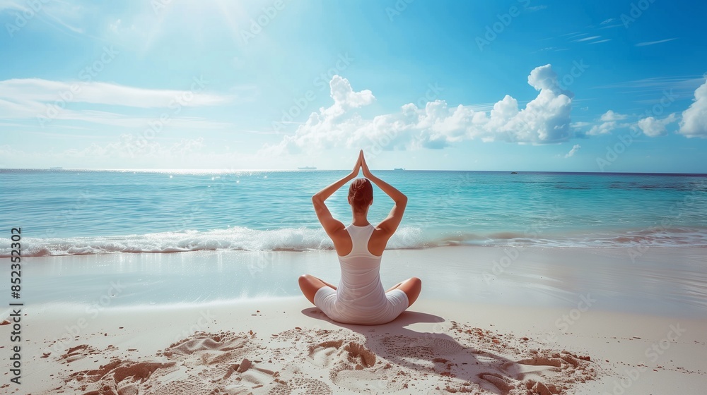 Fototapeta Woman practicing yoga on the beach Yoga by the sea is a meditation and exercise session with a great view