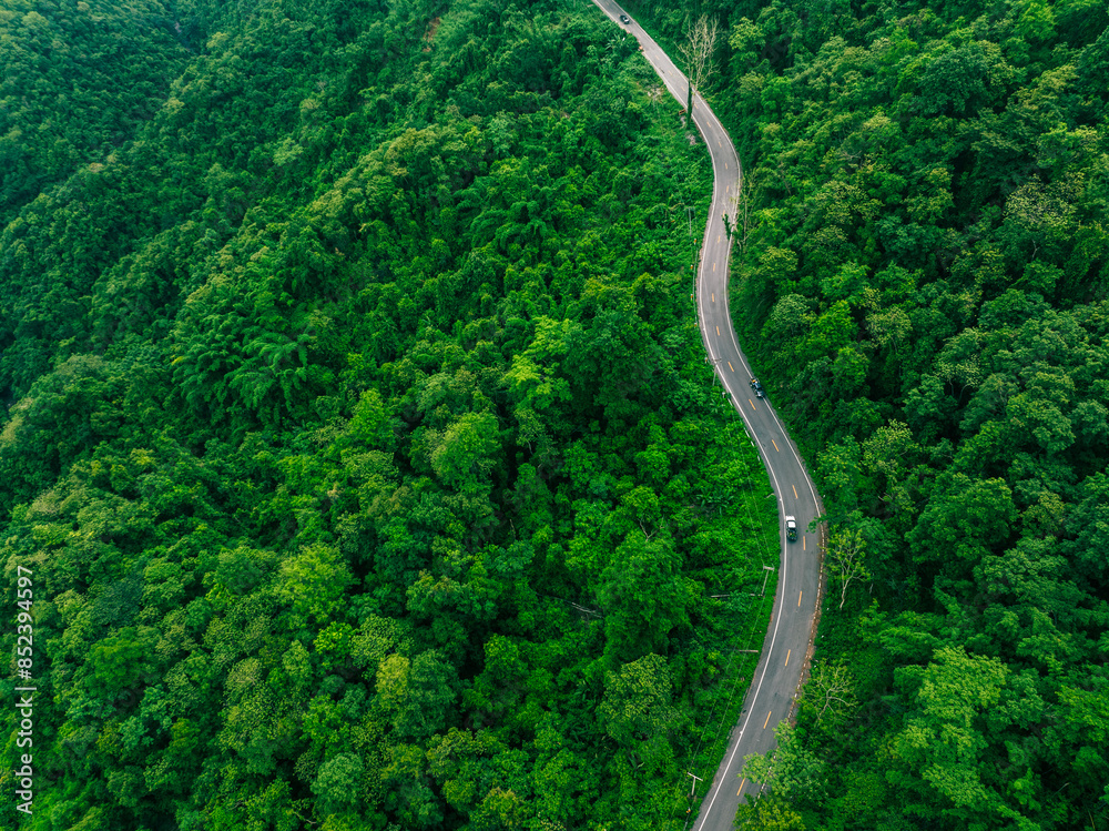 Aerial view of a road in the middle of the forest , road curve construction up to mountain Aerial view of a road in the middle of the forest , road curve construction up to mountain