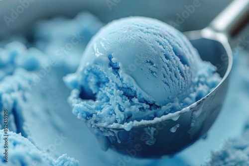 Close-up of a scoop of blue bubble gum flavored ice cream in a metal scoop. photo