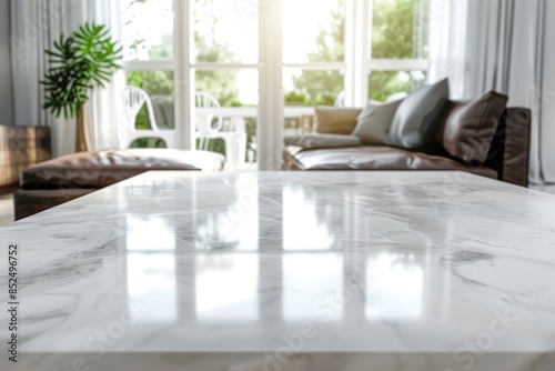 Table with a white marble top placed in front of a bright living room background for showcasing. © Mamstock