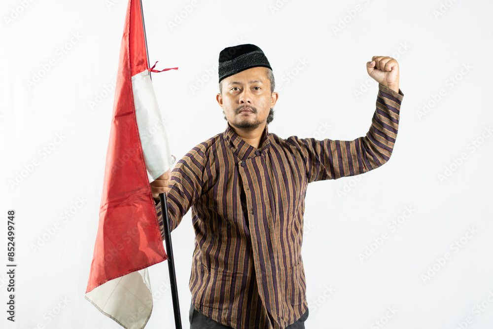 An Asian man carrying a red and white Indonesian national flag and wearing traditional Javanese clothing called LURIK to commemorate Indonesian Independence Day isolated on a white background An Asian man carrying a red and white Indonesian national flag and wearing traditional Javanese clothing called LURIK to commemorate Indonesian Independence Day isolated on a white background