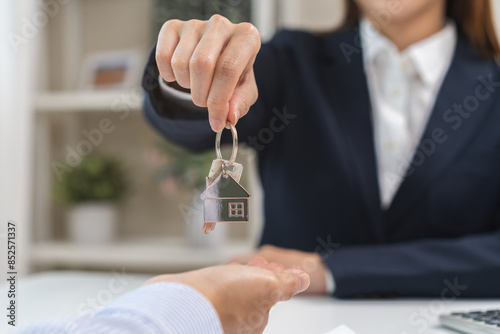Close up agent giving a key to new owner or tenant, client after signed signature contract rental purchase, buyer apartment, home with landlord, realtor. Banker agreement mortgage loan. Property lease