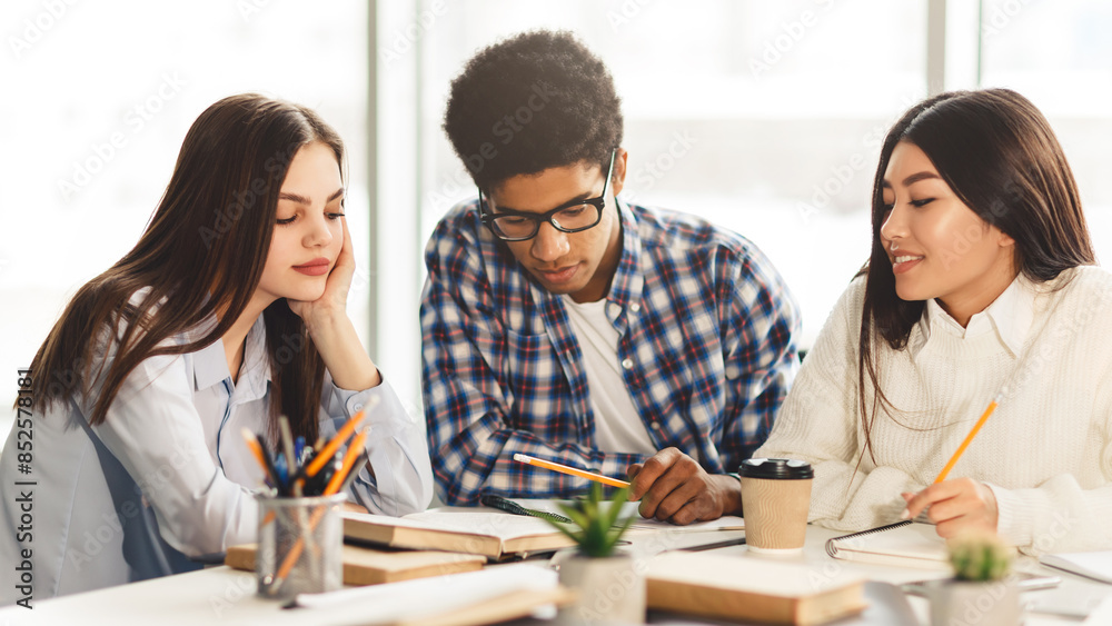 Education concept. High school students studying and reading together in library Education concept. High school students studying and reading together in library