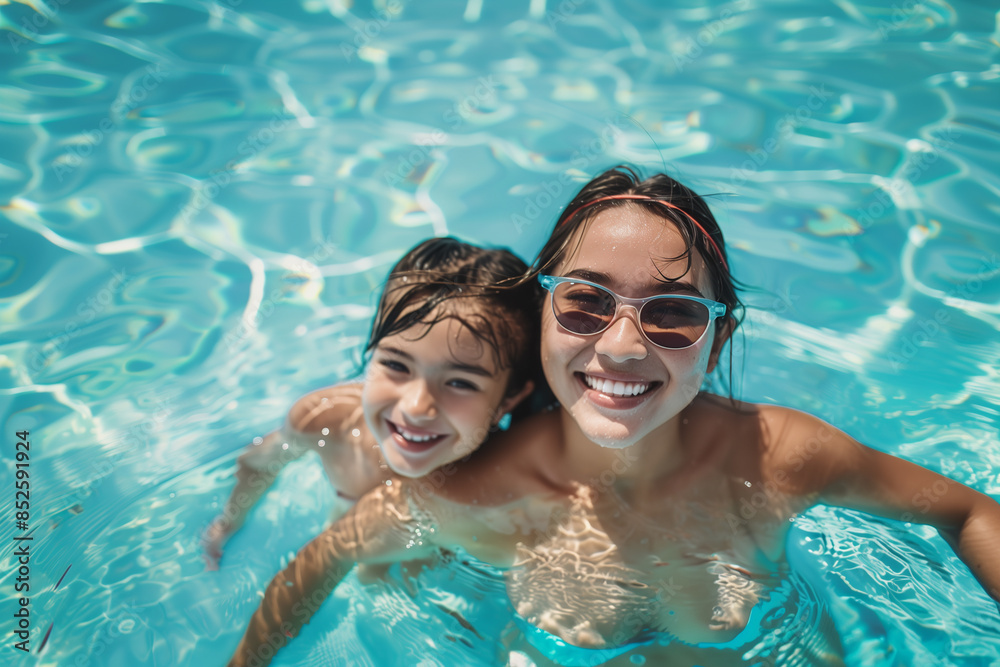 Happy mom and daughter are swimming in the pool. Happy mom and daughter are swimming in the pool.