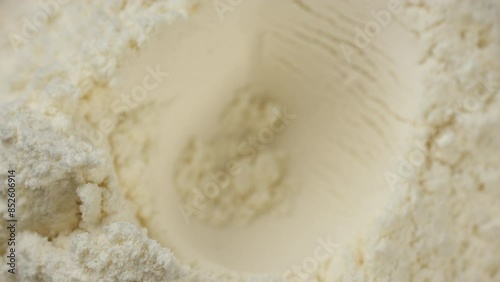 measuring spoon filled with white protein powder