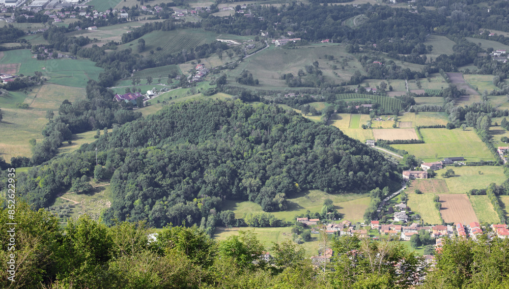 Obraz premium Panoramic view from a hill with many trees and some villages