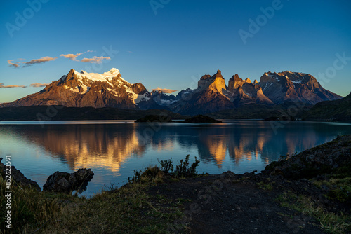 Cerro Paine Grande, Cerro Paine Grande, and Mont Almirante Nieto during a golden sunrise reflected in Lago Pehoe