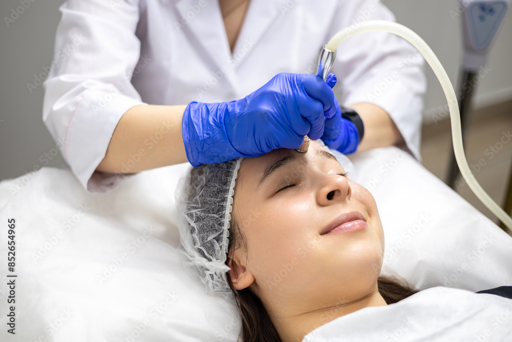 Face Beauty Treatment. Close up of female client getting facial microdermabrasion procedure using hardware apparatus, derma pen. Face Beauty Treatment. Close up of female client getting facial microdermabrasion procedure using hardware apparatus, derma pen.