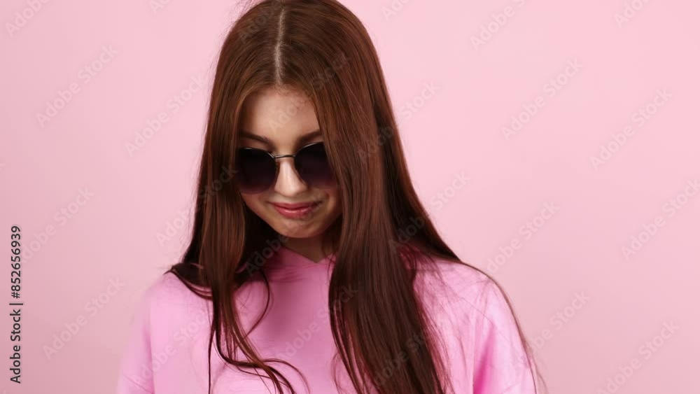 Beautiful young woman model, teenager, close-up portrait, looking at camera, on pink background, posing in sunglasses. Beautiful young woman model, teenager, close-up portrait, looking at camera, on pink background, posing in sunglasses.