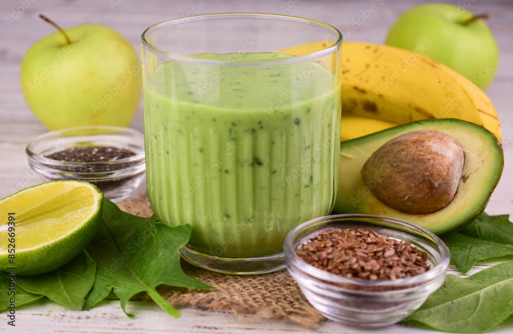 Green smoothie in a glass. Vitamin drink made from avocado, banana, spinach, lime.
Green smoothie in a glass. Vitamin drink made from avocado, banana, spinach, lime.