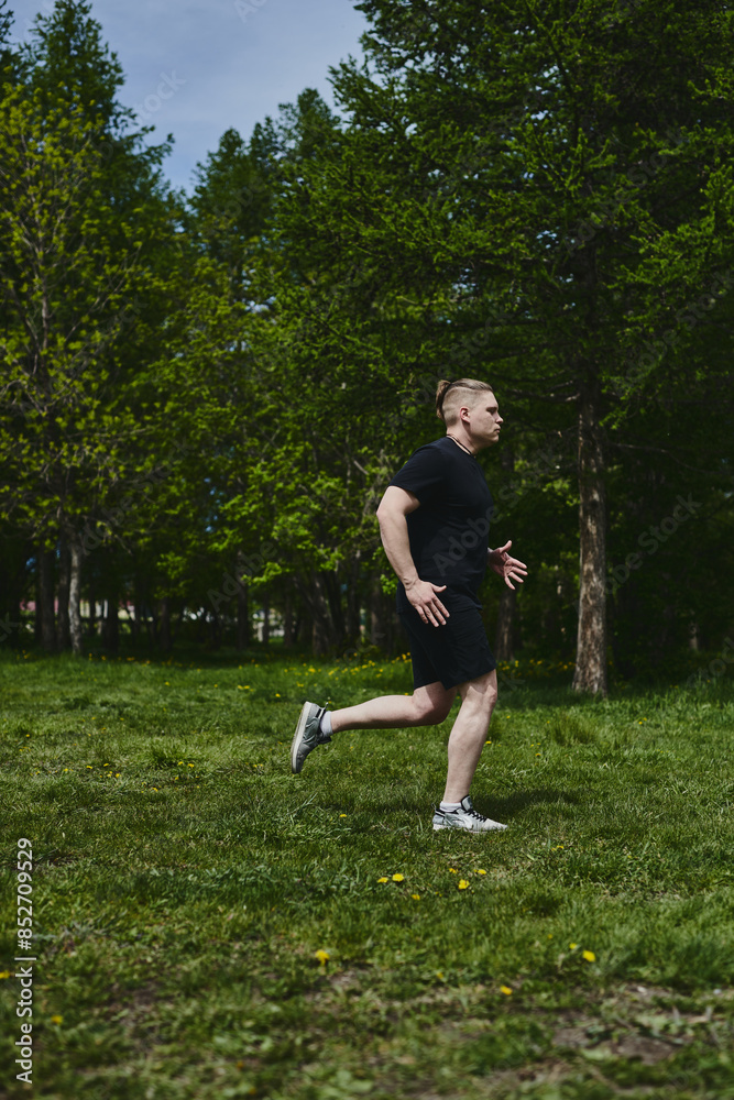 Caucasian male athlete jogging outdoors in a summer park Caucasian male athlete jogging outdoors in a summer park