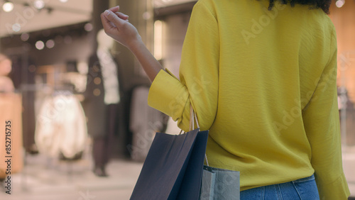 Fotografía Close up back view woman walking going shopping mall holding paper bags buy shop