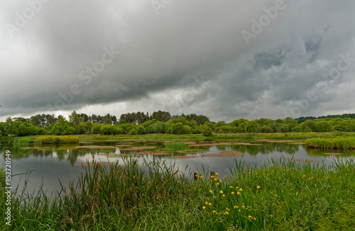 One of the larger lochs of Morton Lochs at Tentsmuir National Nature Reserve in Fife under the dark clouds of a rain Front sweeping in. photo