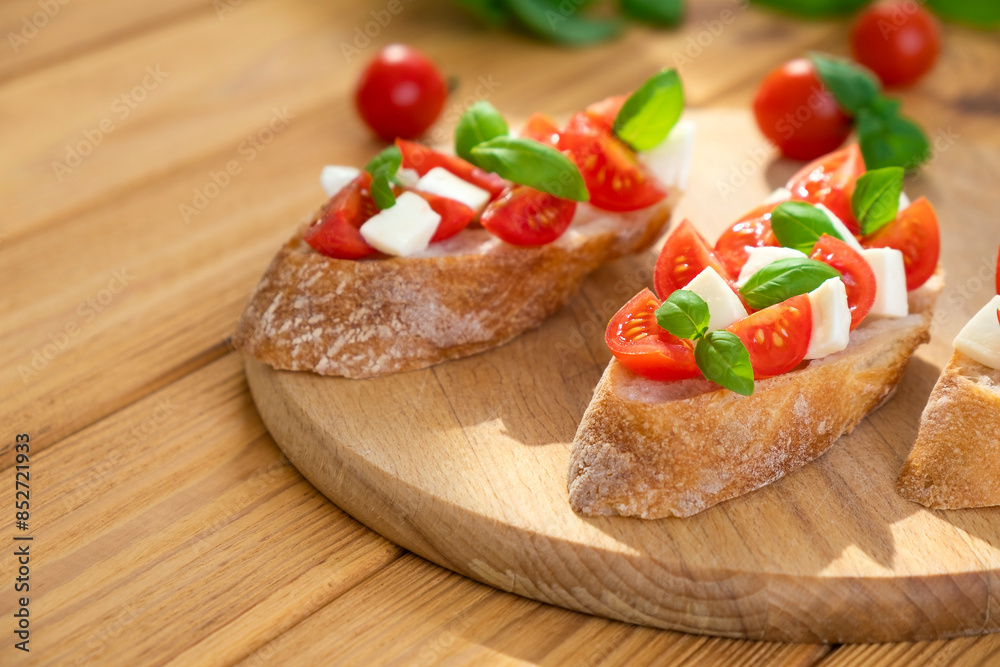 Sandwich with tomatoes, mozzarella cheese and basil on wooden board. Traditional Italian appetizer, toast, snack or antipasto. Vegetarian food. Healthy eating. Mediterranean food. Sandwich with tomatoes, mozzarella cheese and basil on wooden board. Traditional Italian appetizer, toast, snack or antipasto. Vegetarian food. Healthy eating. Mediterranean food.