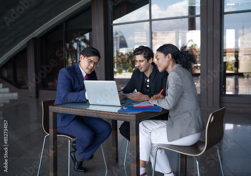 Group of diverse businessperson brainstorming discussing paperwork together. Young multiracial business woman and colleague talking working on startup strategy idea planning. Diversity people teamwork
