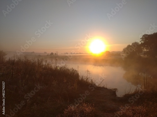 Early morning. The sun rises. River bank.