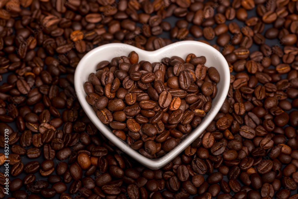 Heart shaped dish with coffee beans and texture background of beans. Love coffee concept. Heart shaped dish with coffee beans and texture background of beans. Love coffee concept.