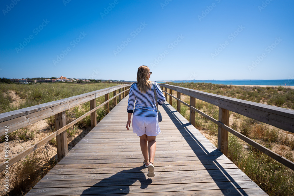 Fototapeta premium Beautiful woman walking on seaside promenade - Portugal, Algarve, Lagos