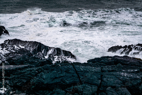 Fototapeta Naklejka Na Ścianę i Meble -  Cliffs in Valahnúkamöl in Iceland in winter time covered with snow, stormy sea, high waves and black rocks