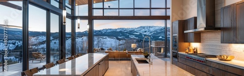 A large kitchen with a view of the mountains. The kitchen is very spacious and has a lot of natural light coming in from the windows. The countertops are made of granite