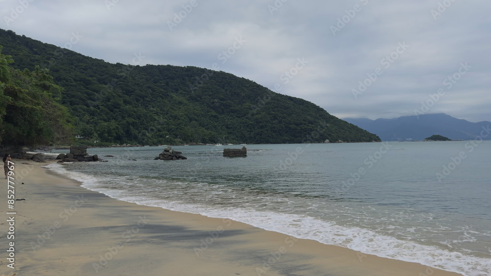 Romantic couple walking along tropical beach shoreline