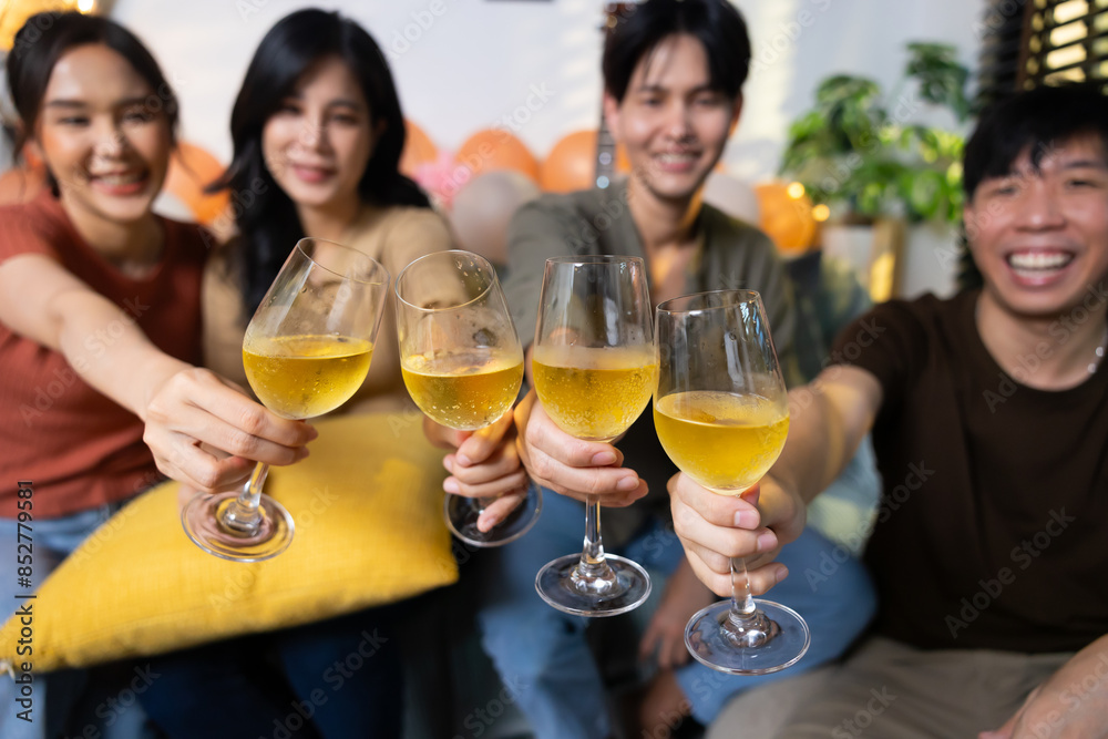 Close up hand holding glass. Group of young asian people smiling friends drinking at birthday party toast with beer. food and beverag Close up hand holding glass. Group of young asian people smiling friends drinking at birthday party toast with beer. food and beverag