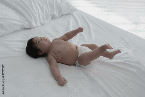 Baby is half Nigeria half Thai, 2-month-old newborn daughter, lying on a white bed. to infant and family concept photo