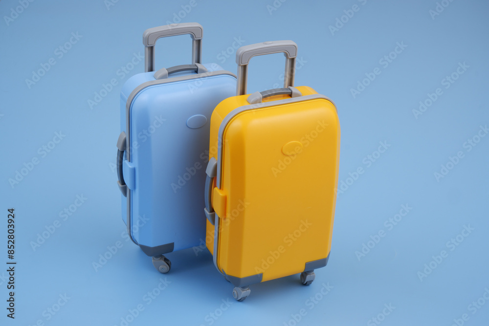 Close up of orange and blue travel suitcase on blue background.