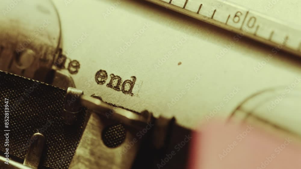 Extreme close-up shot of unrecognizable novelist typing The end with dot on paper with vintage manual typewriter