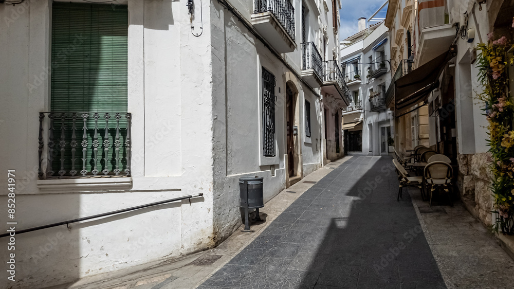 Quiet European alleyway with traditional architecture and closed shutters, evocative of siesta time and Mediterranean lifestyle Quiet European alleyway with traditional architecture and closed shutters, evocative of siesta time and Mediterranean lifestyle