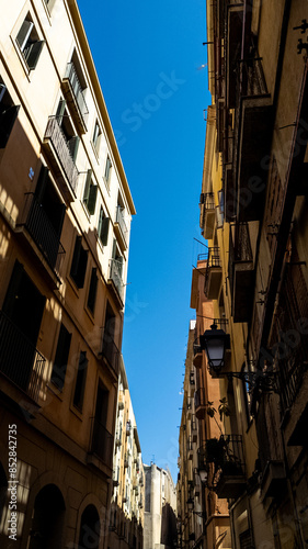 Urban cityscape of narrow alley with traditional European architecture under a clear blue sky, ideal for travel brochures and cultural exploration themes