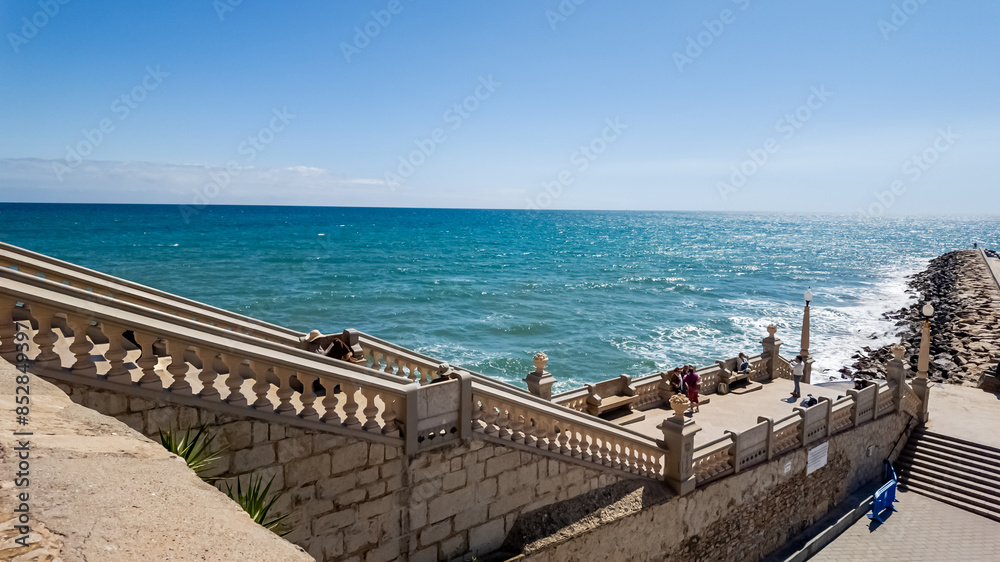 Sunny seaside promenade with decorative balustrade overlooking the turquoise ocean, ideal for vacation and summer travel themes Related concepts: travel, summer vacations Sunny seaside promenade with decorative balustrade overlooking the turquoise ocean, ideal for vacation and summer travel themes Related concepts: travel, summer vacations