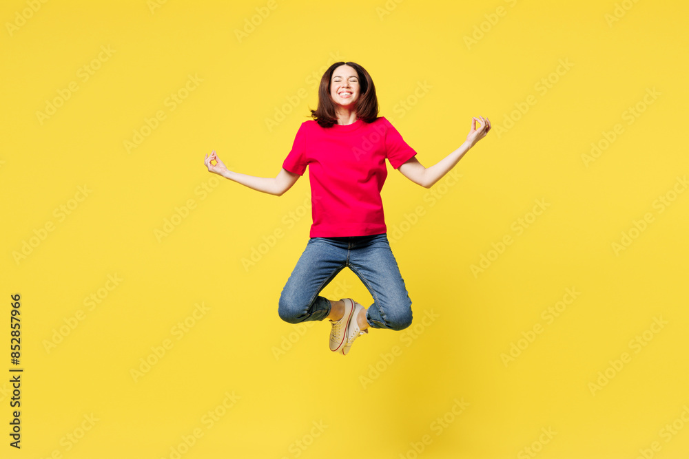 Full body young woman wear pink t-shirt casual clothes jump high hold spread hands in yoga om aum gesture relax meditate try to calm down isolated on plain yellow orange background. Lifestyle concept. Full body young woman wear pink t-shirt casual clothes jump high hold spread hands in yoga om aum gesture relax meditate try to calm down isolated on plain yellow orange background. Lifestyle concept.