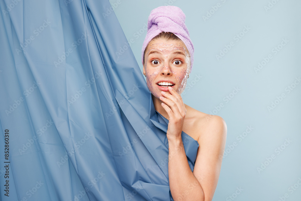 Shocked sad half naked topless young woman with nude make up wear towel covering herself with shower curtain isolated on plain blue color background. Skin care healthcare cosmetic procedures concept. Shocked sad half naked topless young woman with nude make up wear towel covering herself with shower curtain isolated on plain blue color background. Skin care healthcare cosmetic procedures concept.