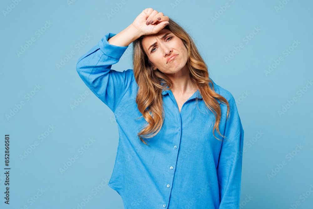Young sad sick ill tired exhausted woman she wearing shirt casual clothes put hand on forehead looking camera isolated on plain pastel light blue cyan background studio portrait. Lifestyle concept. Young sad sick ill tired exhausted woman she wearing shirt casual clothes put hand on forehead looking camera isolated on plain pastel light blue cyan background studio portrait. Lifestyle concept.