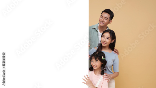 portrait Happy asian family with empty banner for advertising isolated on nude color background.