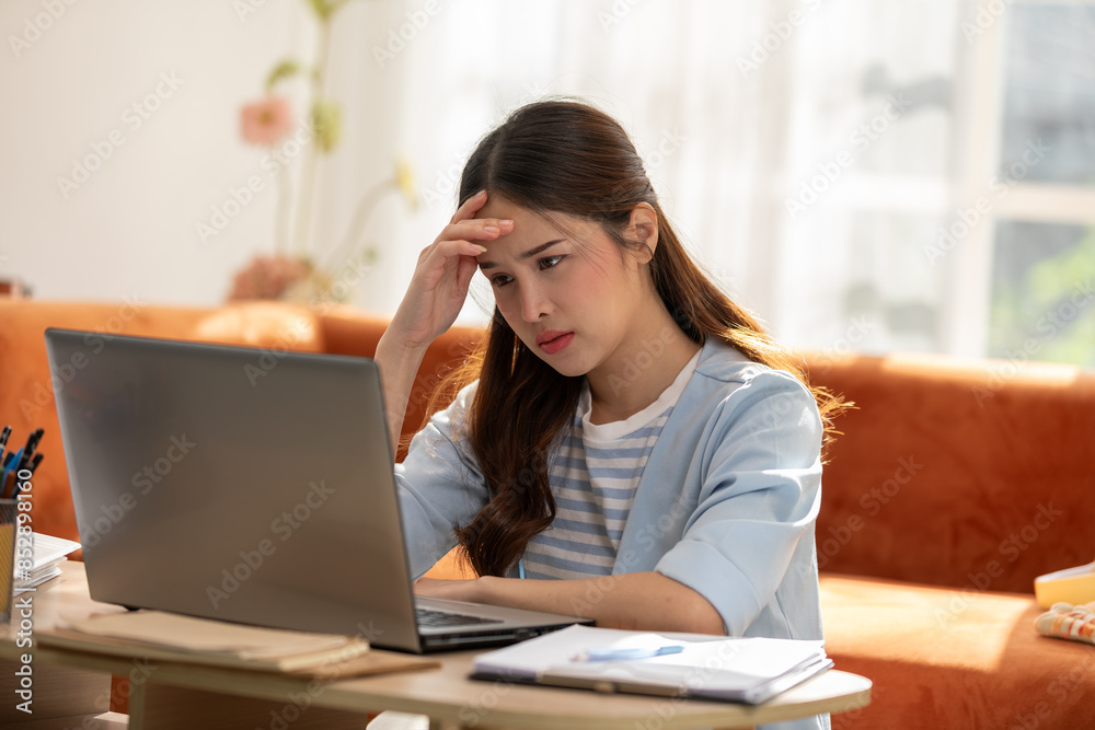 Asian Woman Experiencing Stress While Working on Laptop at Home Asian Woman Experiencing Stress While Working on Laptop at Home