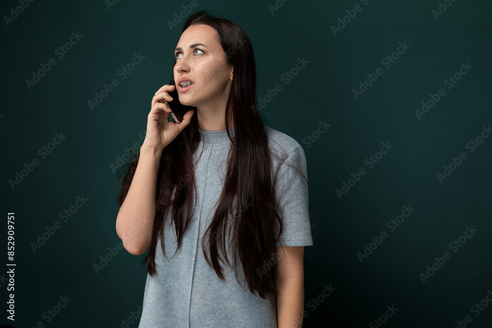 Woman Talking on Cell Phone in Front of Green Wall Woman Talking on Cell Phone in Front of Green Wall