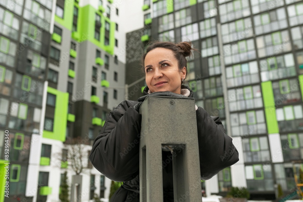 Lifestyle concept, young woman walking in the courtyard of a high-rise building in winter Lifestyle concept, young woman walking in the courtyard of a high-rise building in winter