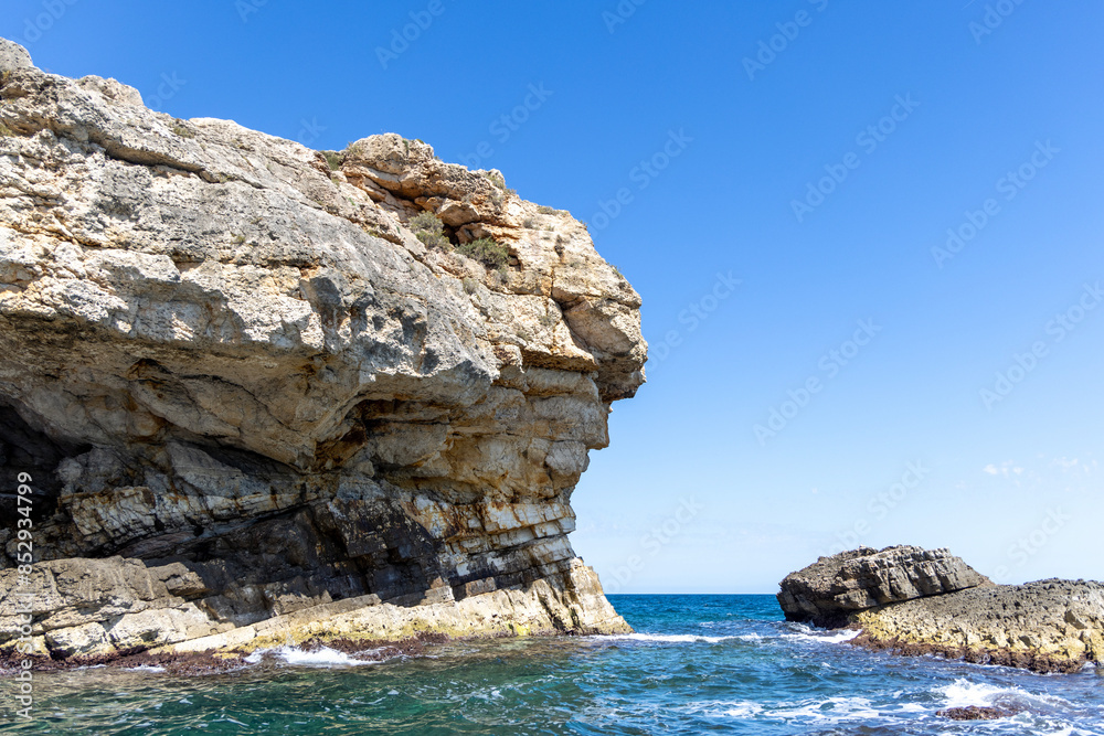 View from the water of picturesque coastline with cliffs and caves by Adriatic Sea, Polignano a Mare, Italy, Apulia