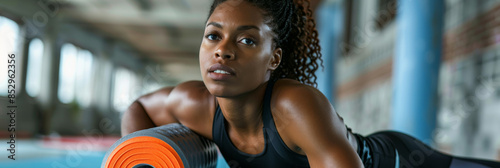 an African American woman using a foam roller to relieve muscle tension after a morning workout photo