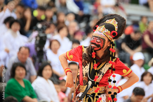 A person performing a mask dance performance in a traditional Indonesian costume