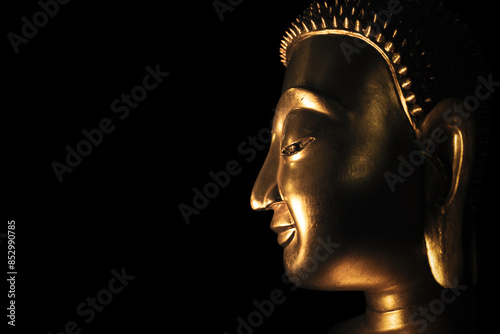 A golden Buddha head on a black background with perfectly placed lights and shadows.