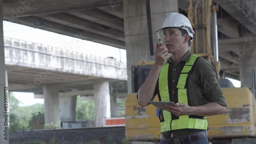 worker using radio communication and tablet on site. workers at construction site.