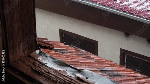 Hail and rain are falling on the briquette roof of the old house. 4k video capture